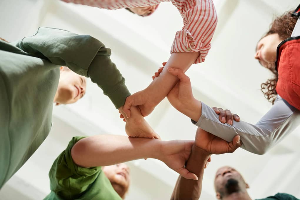 a group of people with their arms linked, symbolizing consensual decision making