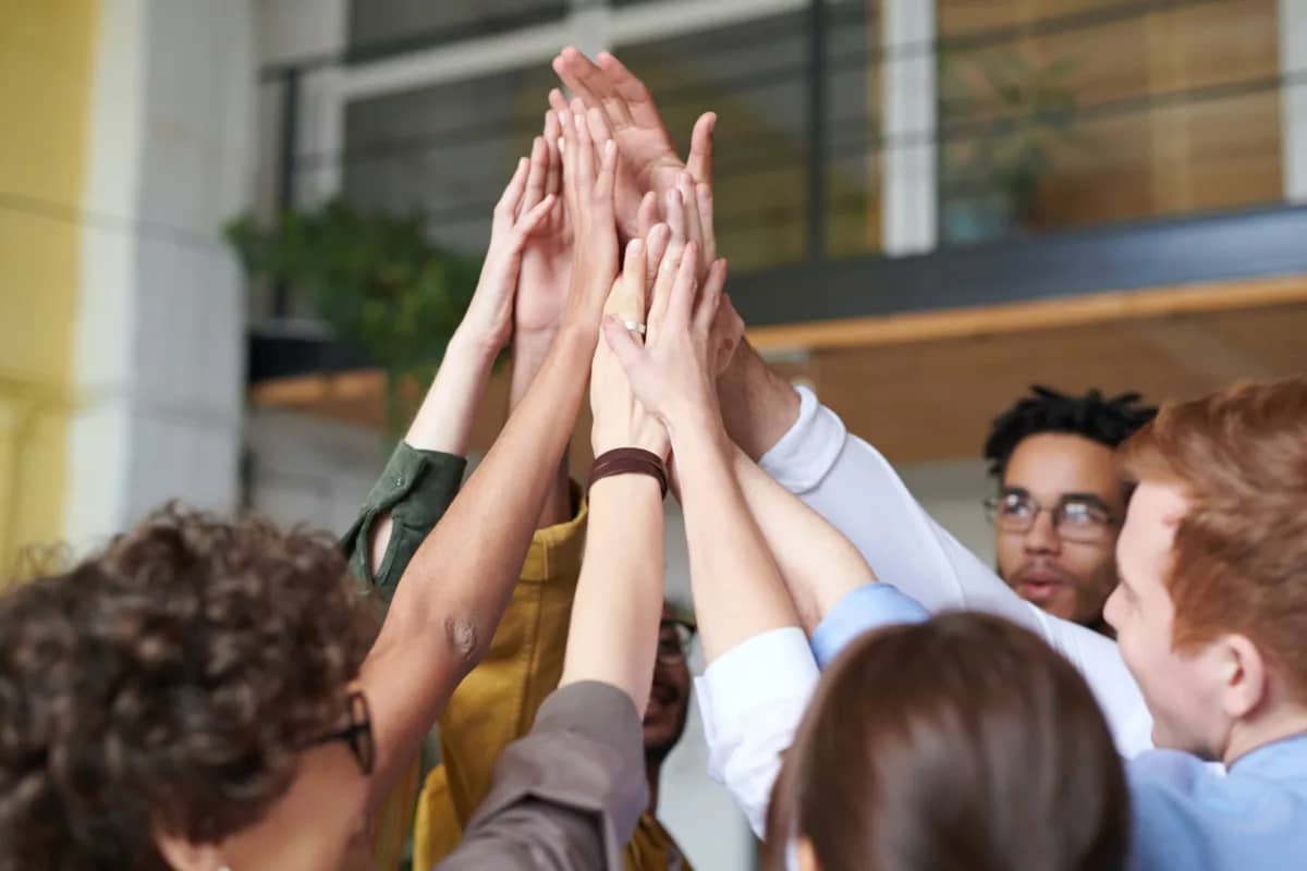 team raising their hands in solidarity