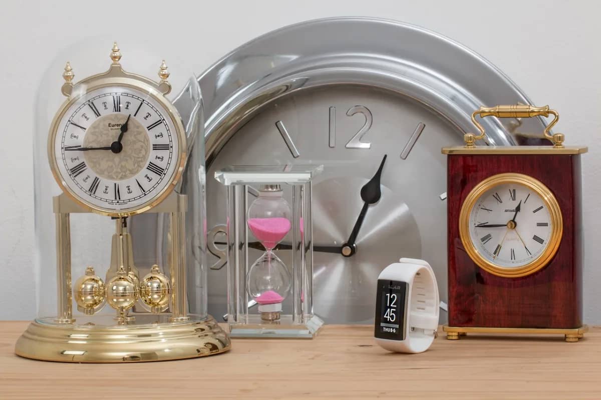 multiple types of clocks on a table, signifying stress and the need for paid time off