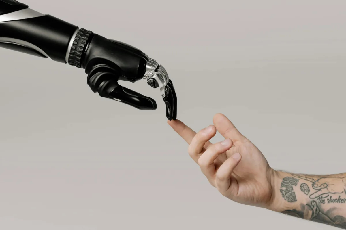 a mechanical hand touching a human hand, a nod to an iconic scene from the movie ET. This also symbolizes applications of ai in business