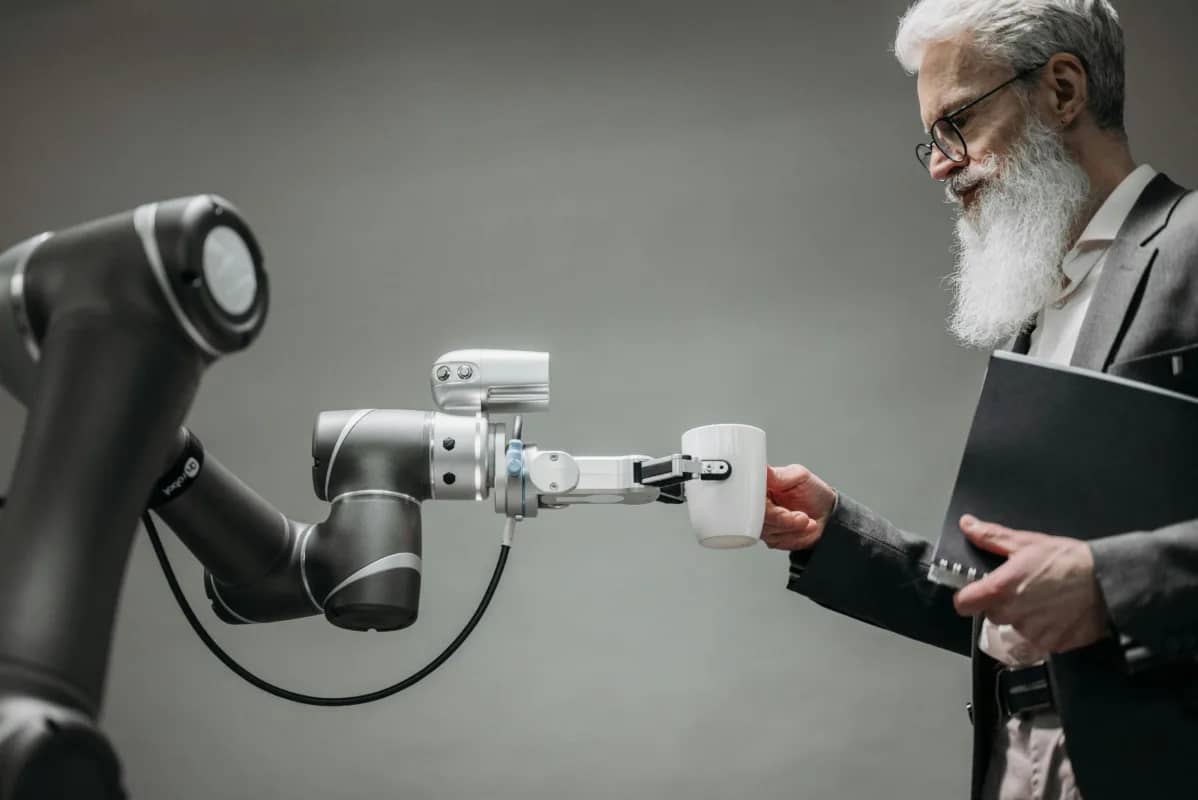 a robot helpfully handing an employee a mug of coffee