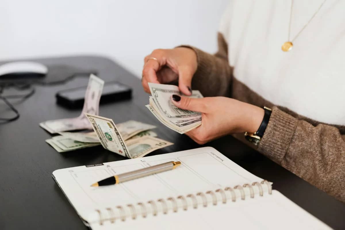 a person counting money, projecting their business' future cashflow