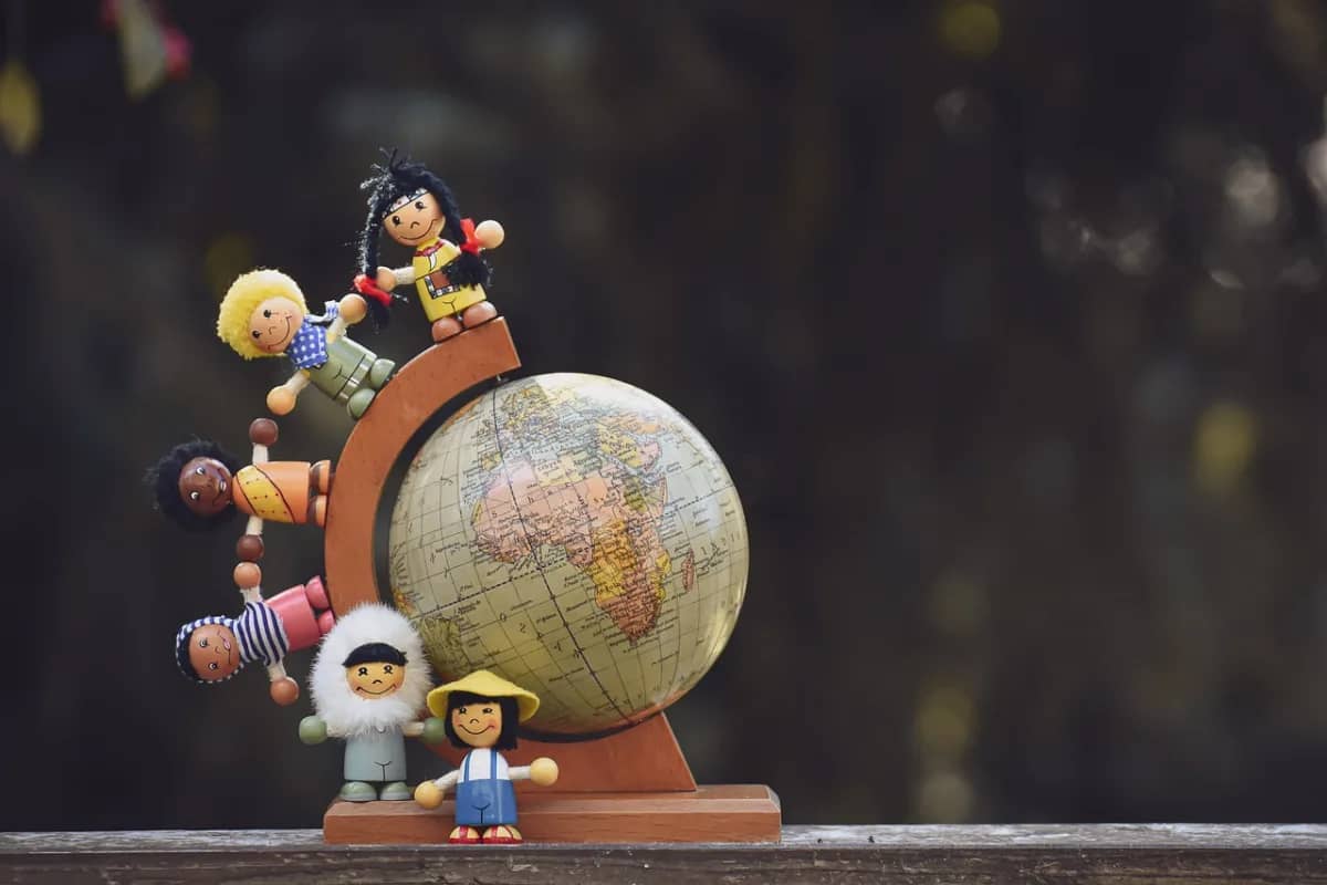 dolls of different nationalities arranged around a globe, signifying the diverse workforce