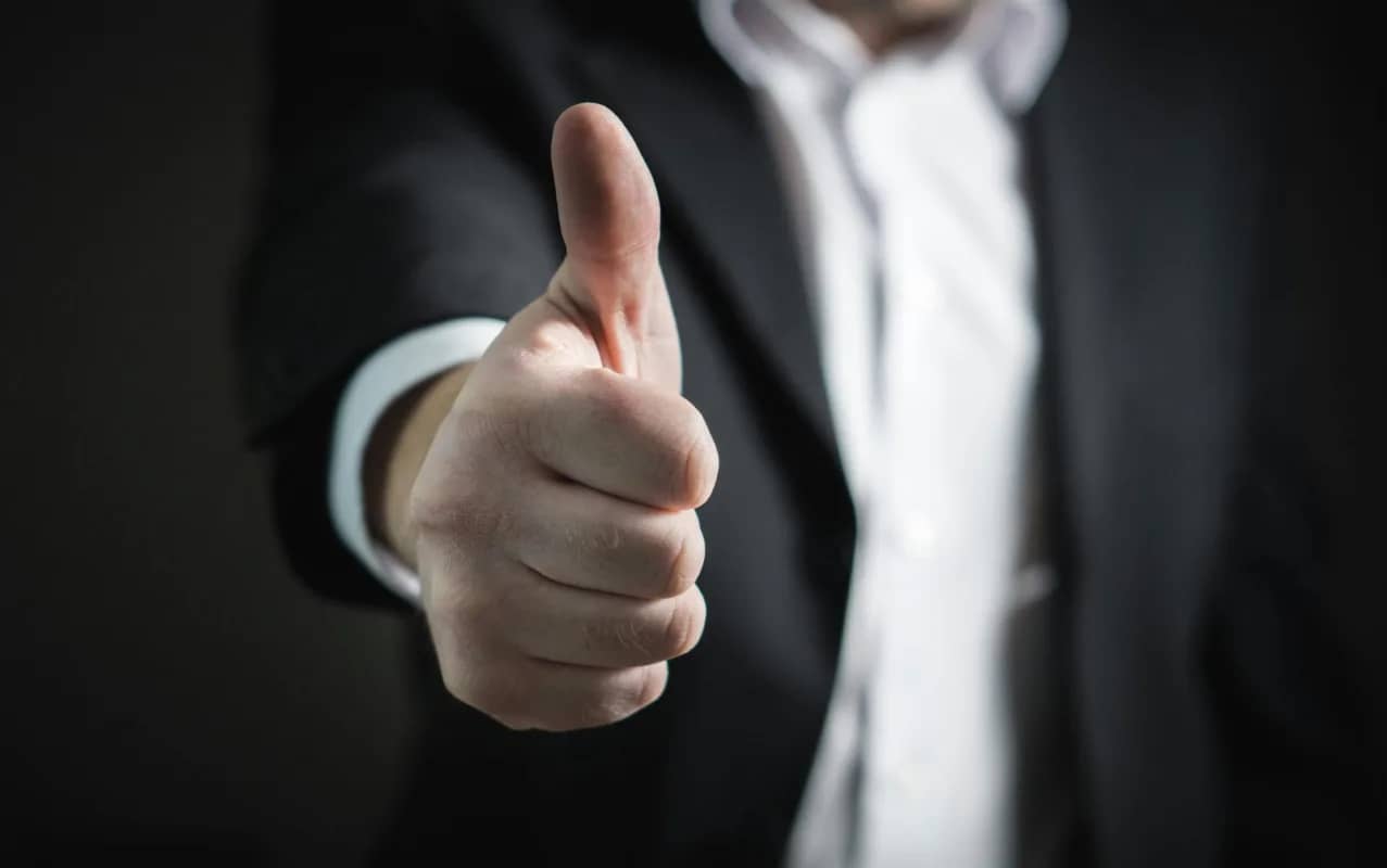 a businessman doing a thumbs up, signifying business success