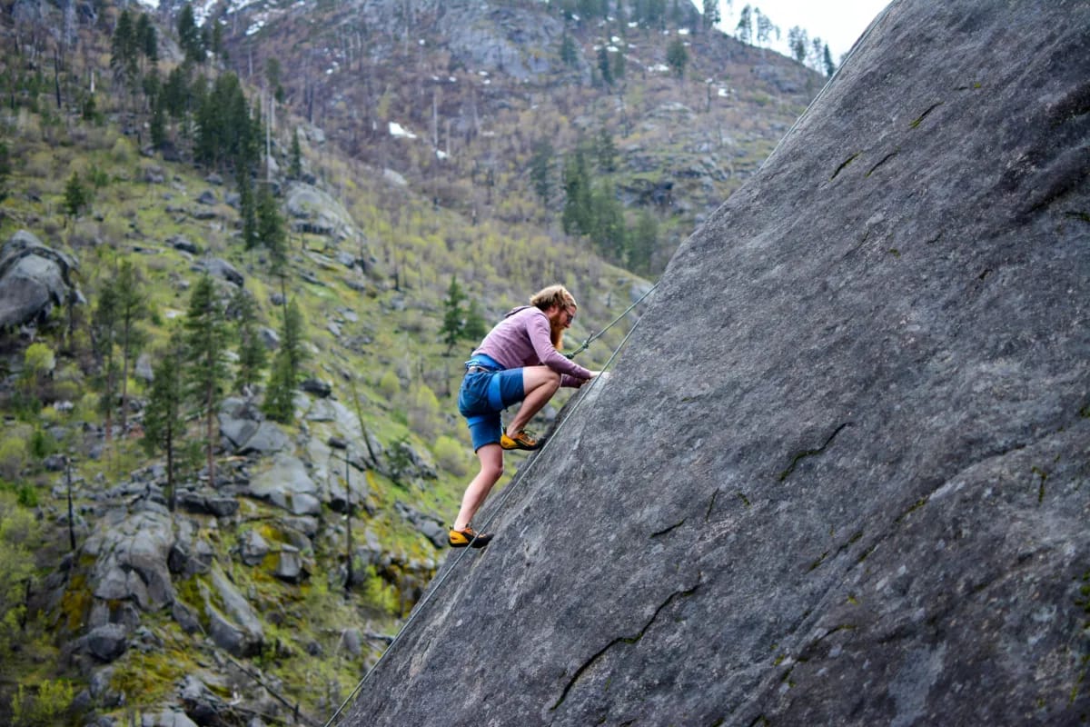 a man climbing up the mountain, alluding to the uphill climb involved with managing business risk