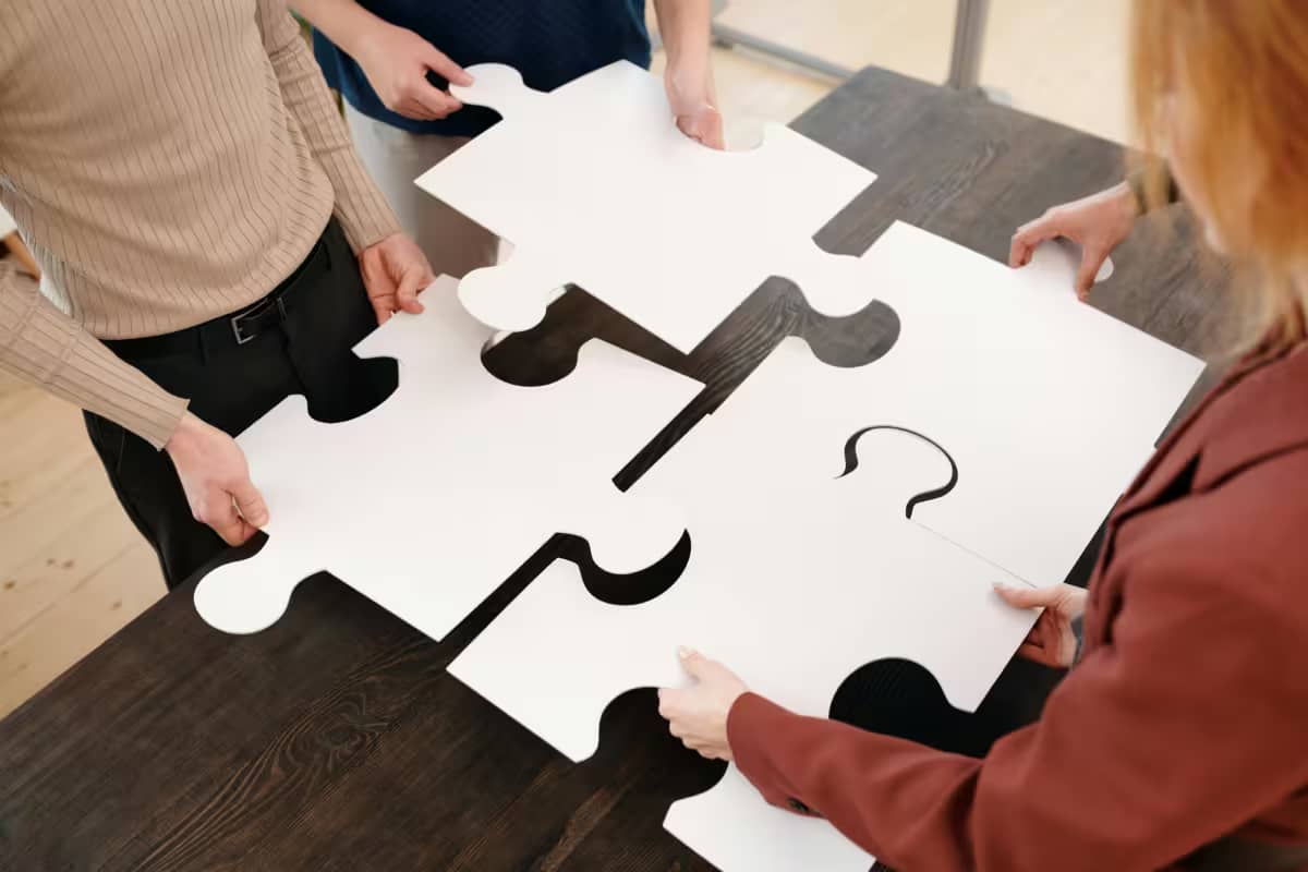 employees putting together pieces of a puzzle, a metaphor for a successful business acquisition