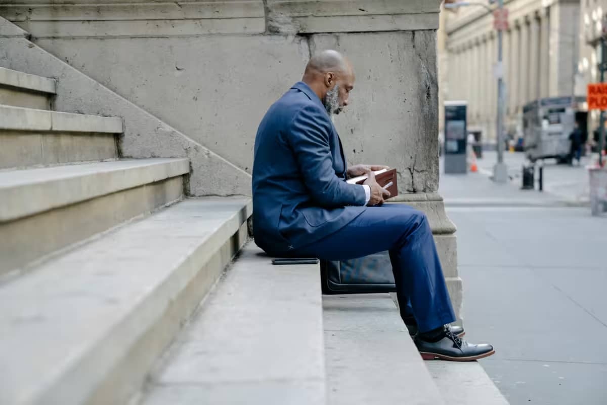 man reading while waiting, showing a dedication to lifelong learning